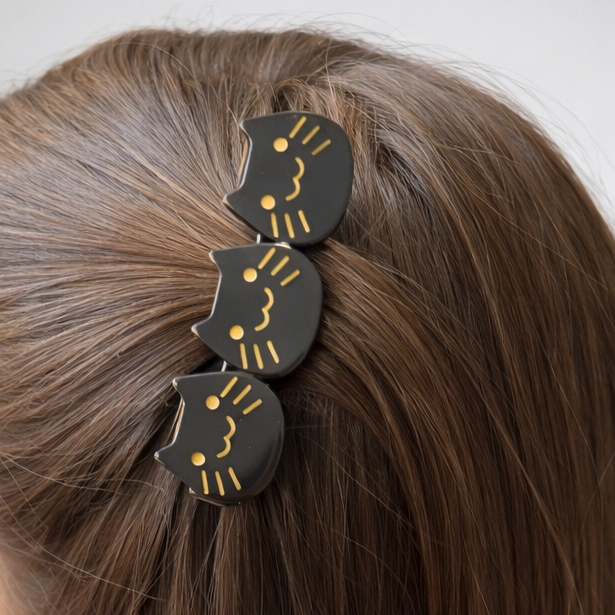 Person with long hair wearing a decorative hair clip against a white background