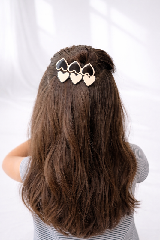 Person with long brown hair wearing a decorative hair clip on a white background