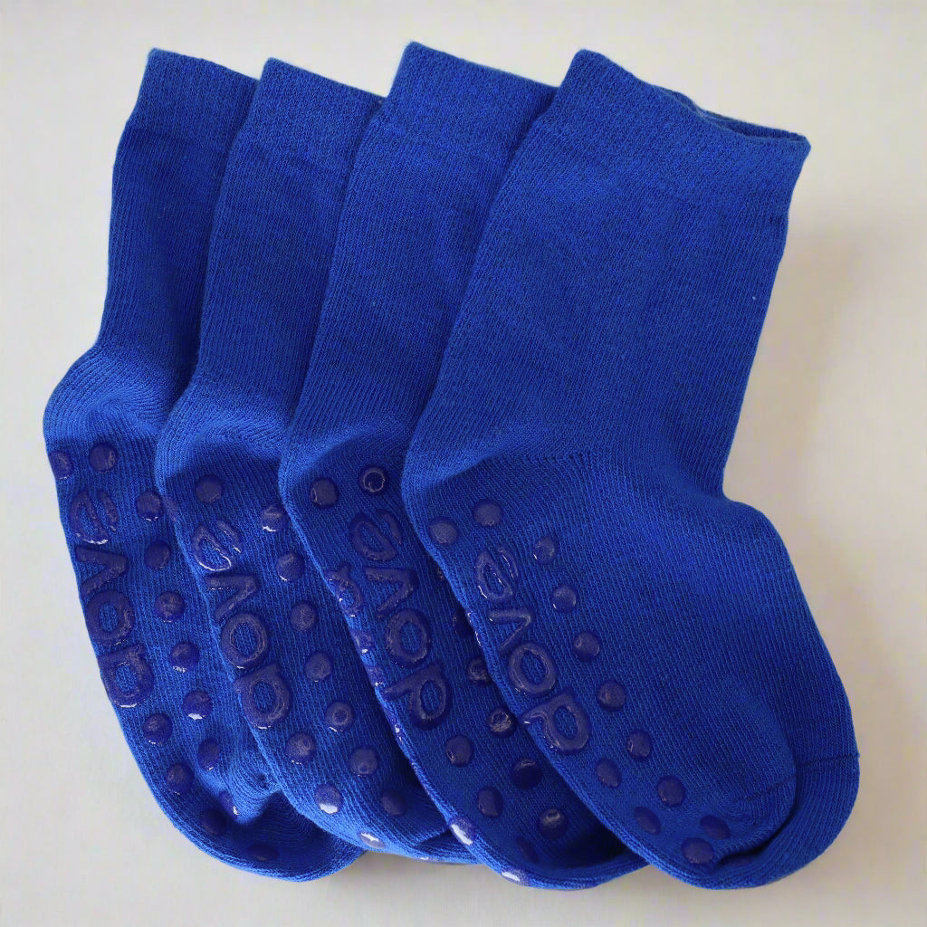 Four pairs of blue socks with textured sole on a light gray background