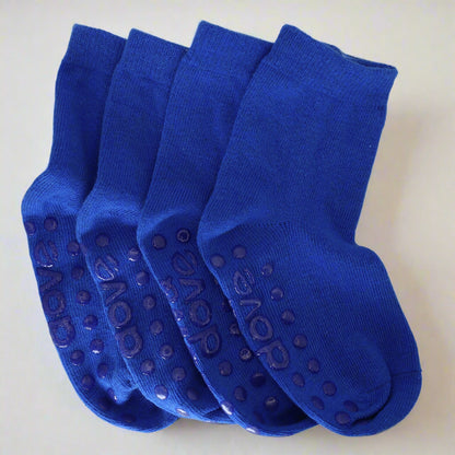 Four pairs of blue socks with textured sole on a light gray background