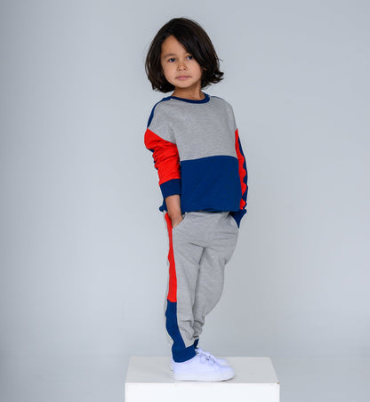 Child wearing a colorful sweater and gray pants on a white background