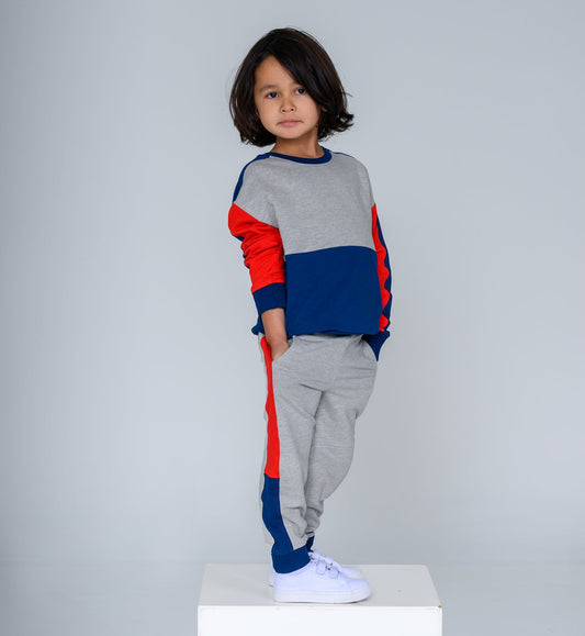 Child wearing a colorful sweater and gray pants on a white background