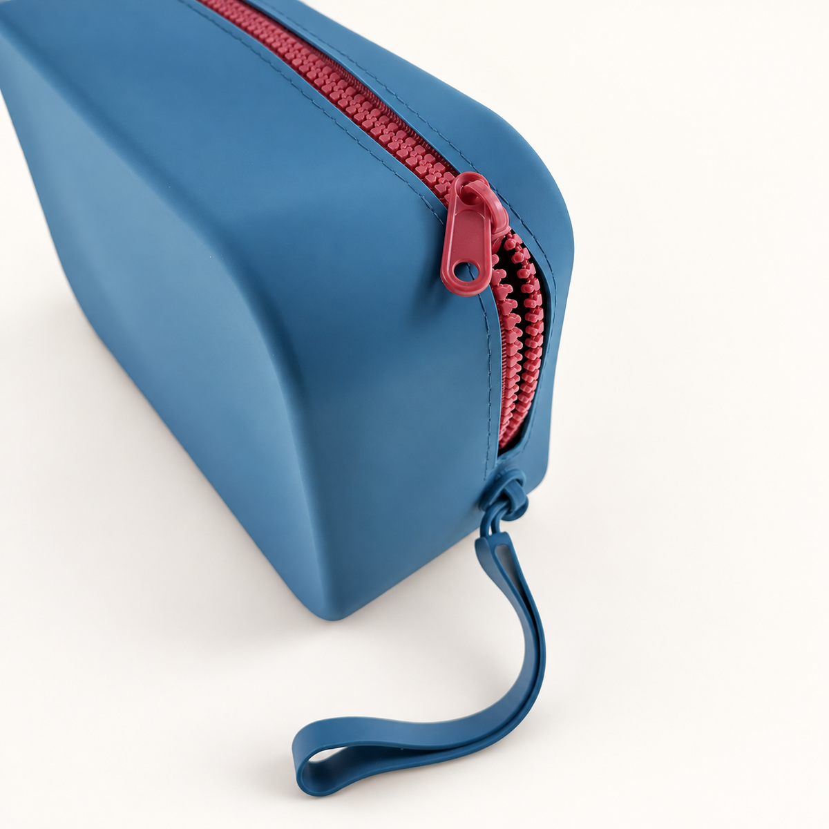 Dew & Dove Color Pop Silicone Zip Pouch in Sky Pop with coral zipper and wrist loop